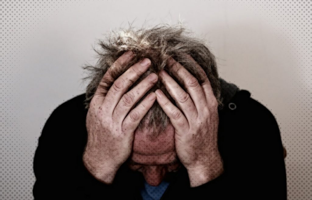 Man holding head in hands